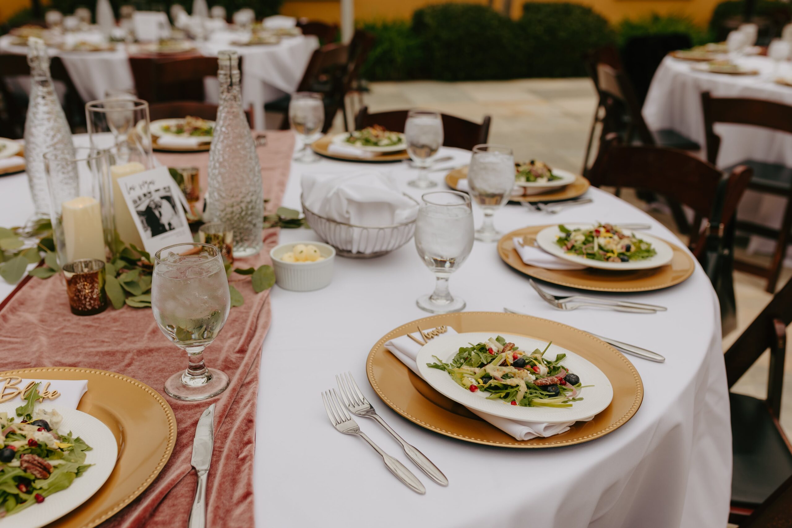 Plates and cups neatly arranged on a table, with two additional tables nearby, set for an event or gathering.