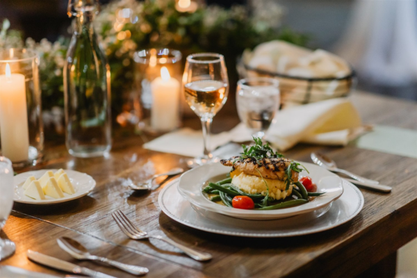 A gourmet plated wedding meal with grilled fish, vegetables, and elegant table decor in Wake County, NC.