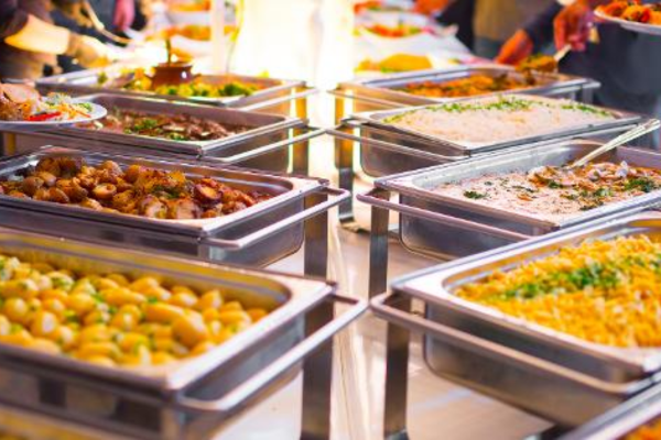 Sleek indoor buffet table with plated sandwiches, salads, and beverages for a corporate event